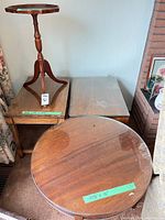 Group shot of all four tables: two rectangular end tables, round glass-top table, pedestal plant stand