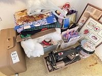 Group view of sewing machine, fabrics, batting, notions bin, frames, tin