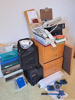Full view of filing cabinet with office supplies, baskets, luggage and hardware around