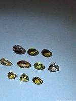 Ten loose faceted gemstones displayed on light background