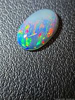 Top view of oval cabochon Ethiopian black opal showing strong play-of-color