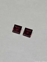 Pair of square red gemstones side by side