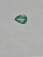 Pear-cut emerald front view on neutral background