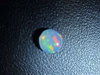 Round jelly opal showing blue dominant face with colour flashes
