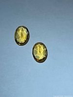 Pair of oval golden citrines on flat background