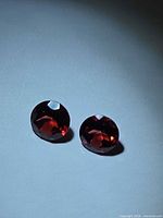 Pair of round red garnets on neutral background