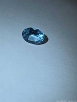 Top view of the blue topaz showing oval shape and faceting