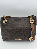 Front view of bag showing MK monogram, gold chain straps, logo charm