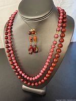 Necklaces displayed on bust with earrings