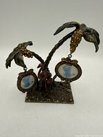 front view of metal palm tree stand showing frames and flamingos