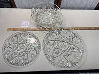 overview of three pressed glass pieces with ruler for scale