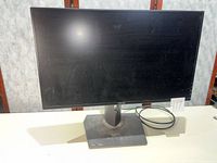 Front view of ASUS ROG monitor on stand with USB cable visible
