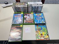 Overall lot showing stacked cases and six laid-out Xbox/GameCube cases