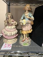 Front view of both porcelain figurines on shelf
