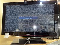 Front view of Samsung 32-inch TV displaying "Weak or No Signal" screen