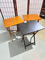 Front view of three folding tray tables