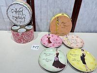 Open paisley hat-box showing mug compartments and four salad plates laid out