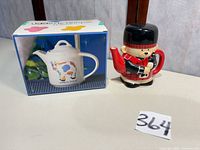 Both teapots side by side with Udderly Unique box