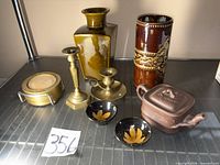 Group shot showing all items: teapot, two bowls, two candlesticks, coaster set, two vases