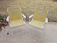 Two matching yellow mesh folding lawn chairs on patio