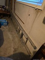 Aluminum extension ladder collapsed leaning against wall