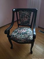 Front view of dark wood accent chair with floral seat and back upholstery