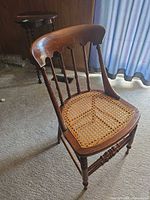 Front view of wooden spindle-back chair with cane seat