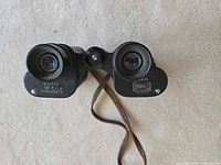Compact Supreme 7x30 binoculars eyepiece view showing markings and strap