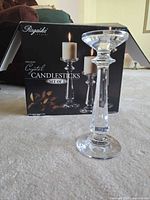 Box showing brand Rogaska and one candlestick displayed