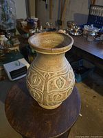 Front view of stoneware vase showing carved leaf pattern and speckled finish