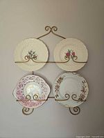 Four plates displayed on gold-tone wall rack