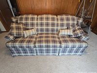 Front view of plaid three-seat sofa with four pillows