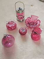 All six cranberry glass items arranged on floor