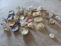 Lot overview showing wrapped stacks of plates and several cups and saucers