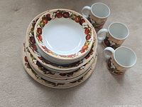 Stacked dinnerware showing plates, bowls, mugs