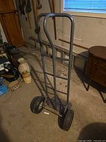 Full view of gray metal hand truck showing wheels and frame