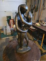 Full view of bronze-finished composite sculpture of embracing couple on display table