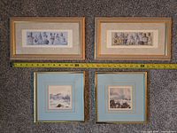 Overview of four framed prints on carpet with tape measure for scale