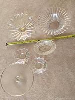 All six clear iridescent glass serving pieces with tape for scale