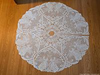 Full view of circular crocheted tree skirt laid flat showing pattern and center opening