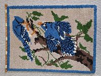 Hooked wall hanging with blue birds on branch