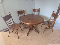 Round oak pedestal table with four matching pressed back chairs