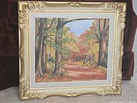 Full view of framed oil painting depicting forest path