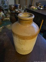 Front view of the stoneware preserving jar showing two-tone glaze, beaded band, neck and rim