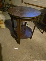 Round two-tier solid wood end table standing upright