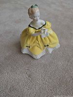 Front view of lady figurine in yellow dress