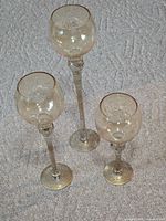 three glass stemmed candle holders