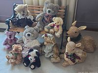 Overall group showing bench with three named Applause and Ganz bears plus others on floor