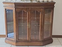 Front view showing double glass doors, brass handles, glass shelf inside