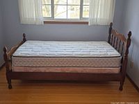 Fully assembled twin bed with mattress and box spring under window